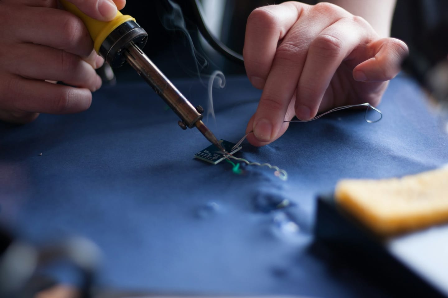 Person using soldering iron.