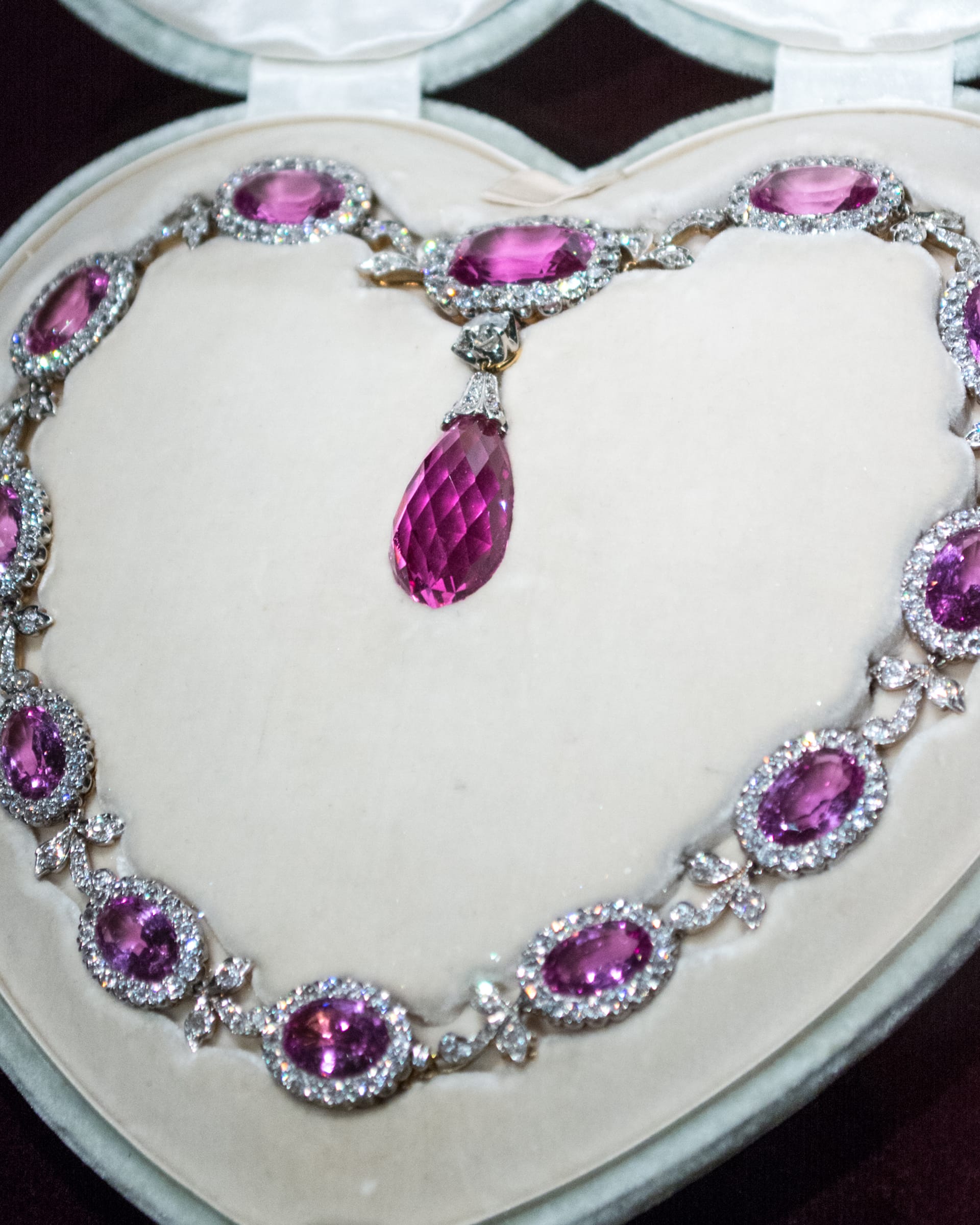 Graduated pink tourmaline and diamond necklace arranged in an open presentation case.